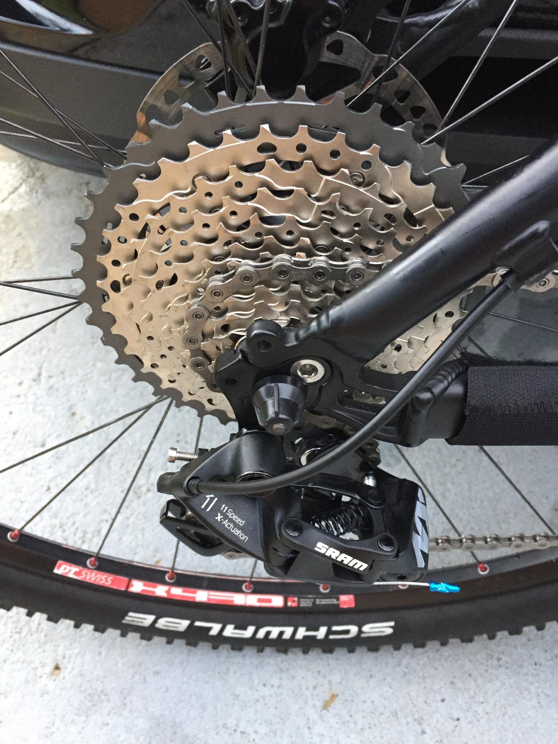Giant Talon 29er: Alt tag: Close-up view of a bicycle's rear cassette and derailleur, showcasing multiple sprockets and a SRAM derailleur, with a portion of a black wheel and tire visible in the background.