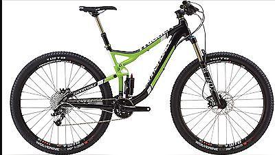 Cannondale Trigger 3: Mountain bike with a black and green frame, featuring wide tires, a shock absorber, and a modern design suitable for off-road riding.