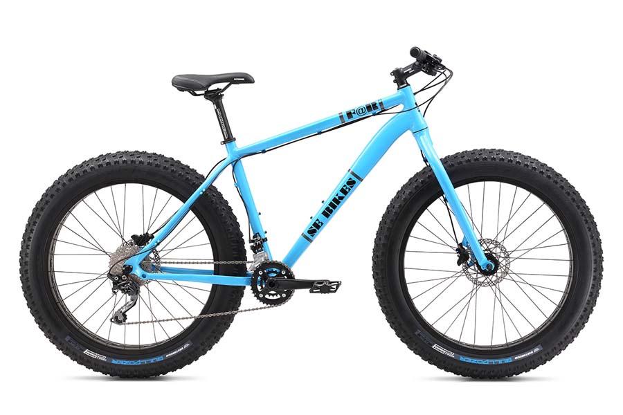 SE F@r: A bright blue fat bike featuring wide tires, a sturdy frame, and a single speed drivetrain. The bike's design is suitable for off-road trails and snowy terrains, showcasing a sleek, modern aesthetic.