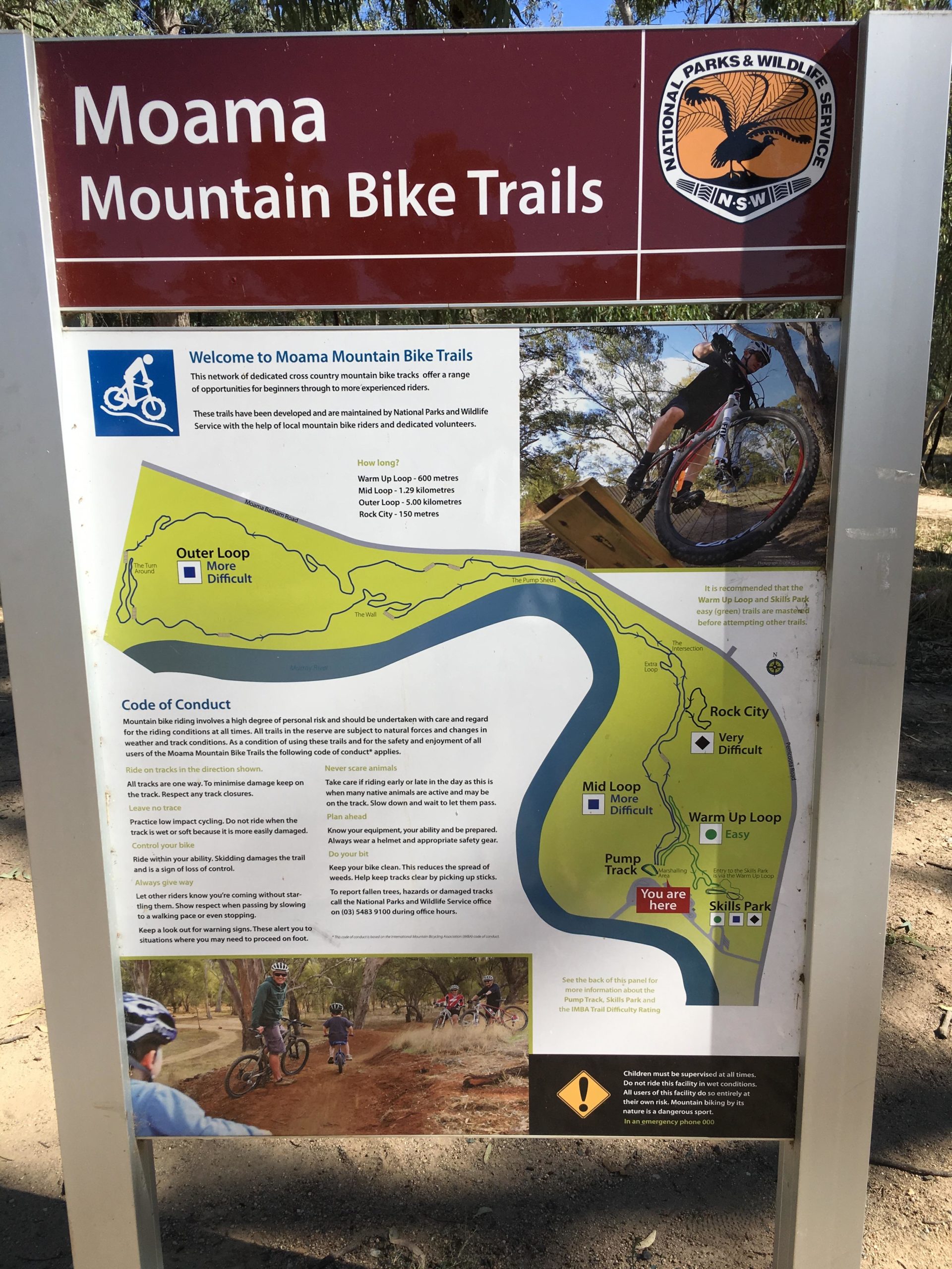 Signage for Moama Mountain Bike Trails, featuring a welcome message, a map of the trails with different difficulty levels, and guidelines for safe biking practices. The sign includes details on trail lengths, a code of conduct for riders, and an illustration of a biking activity. Moama Five Km Outer loop trail mountain bike trail.