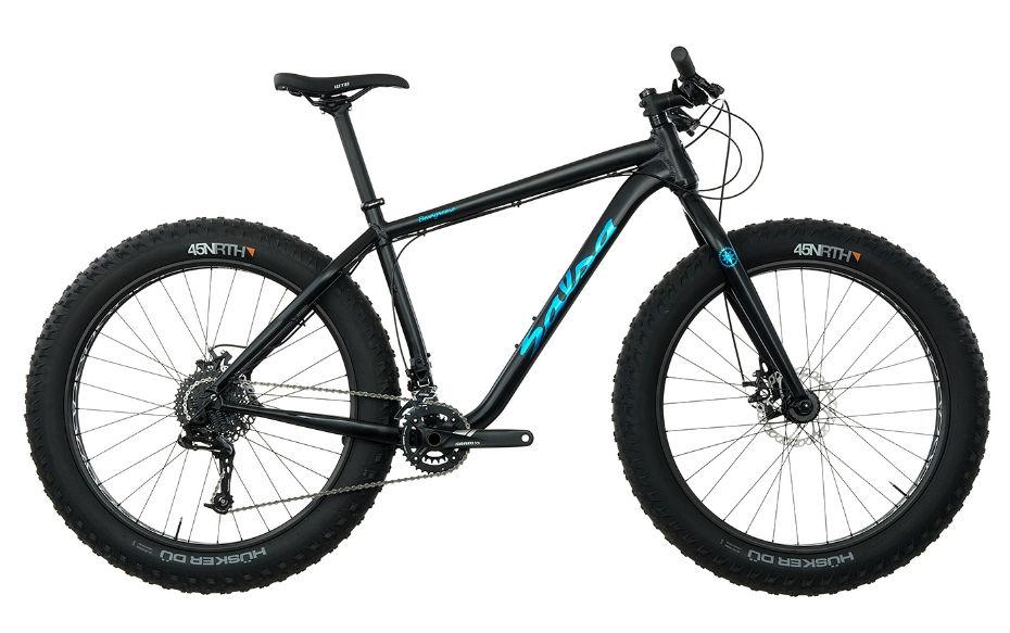 Salsa Beargrease X5 2x10: A black fat bike with blue accents, featuring wide tires designed for off-road terrain. The bike has a sturdy frame, a single gear setup, and disc brakes for enhanced performance. The handlebars are straight and the seat is positioned for a comfortable riding posture.