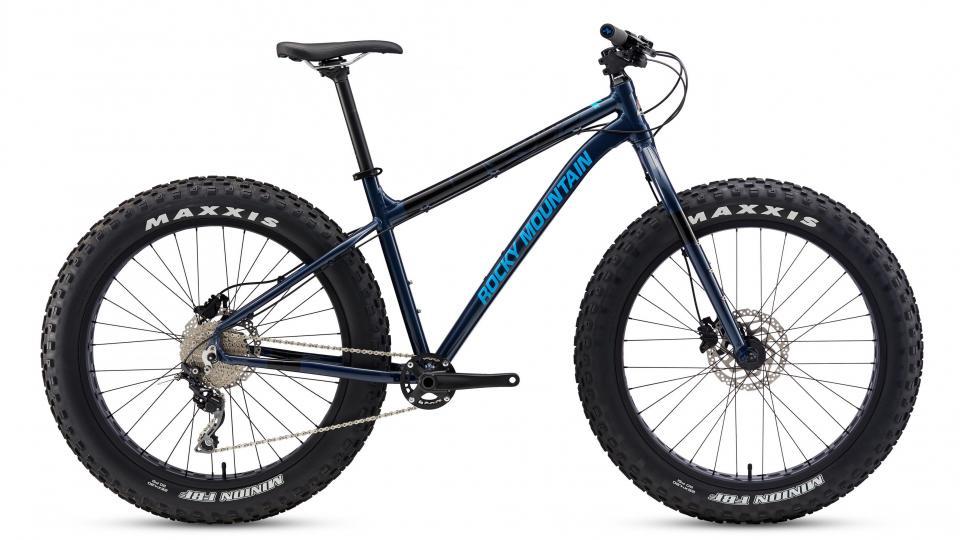 Rocky Mountain Blizzard -20: A blue Rocky Mountain fat bike with large, knobby tires, featuring a sleek frame, disc brakes, and a modern design, positioned on a white background.