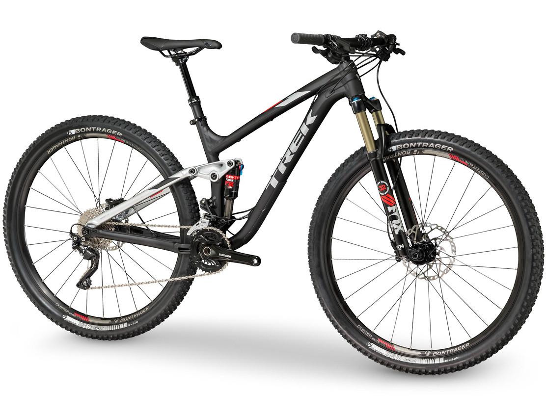 Trek Fuel EX 8: A black and silver mountain bike with a sleek design, featuring wide tires with tread patterns suitable for off-road terrain. The bike has front suspension forks, a sturdy frame, and a well-defined drivetrain. The handlebars are equipped with grips for better control. The bike is positioned on a white background, emphasizing its modern style and features.