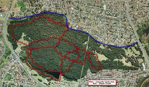 Aerial map highlighting bike and walking paths in a park area. The blue line indicates the concrete cycleway, while the red lines mark the shaded trails. Surrounding the park are residential neighborhoods. Blackbutt forest mountain bike trail.