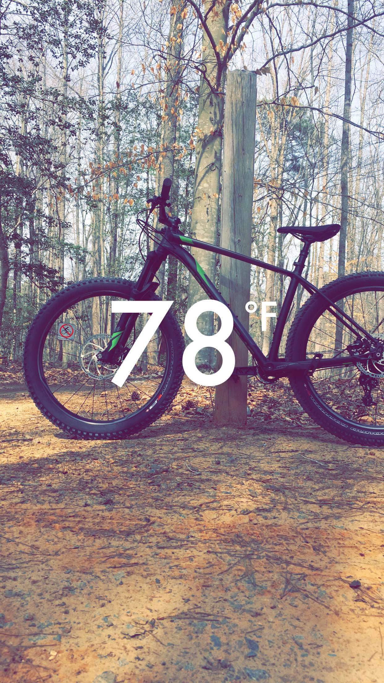 Specialized Fuse: A mountain bike parked on a dirt trail surrounded by trees, with a temperature reading of 78°F displayed prominently in the foreground.