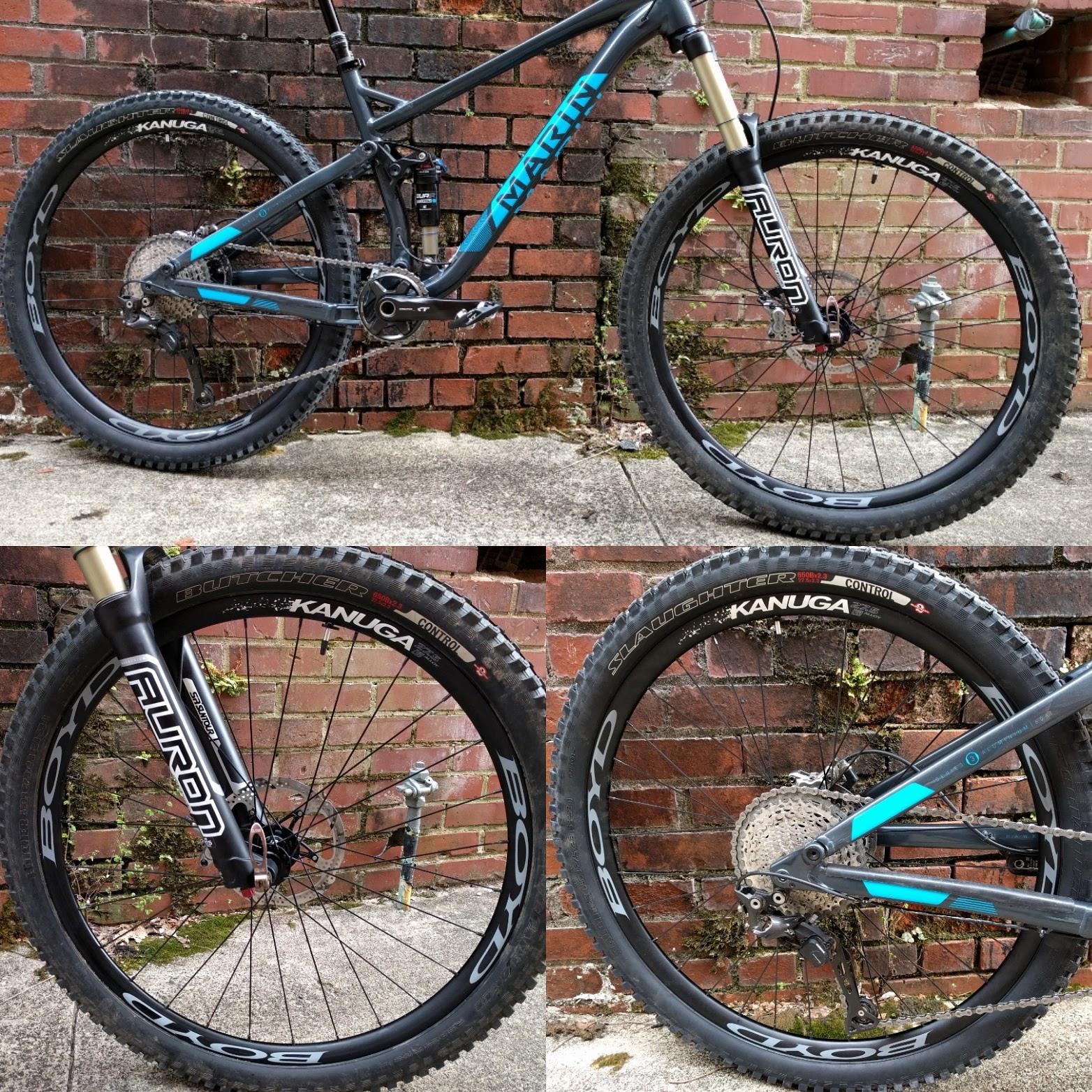 Marin Hawk Hill: Image of a mountain bike showcasing its frame, suspension system, and wheels. The bike features a black and blue color scheme, and is positioned against a brick wall. Close-up views highlight the wheels equipped with Boyd rims and Kenda tires, labeled with "Butcher" and "Slaughter" designs. The bike's details illustrate its off-road capabilities.