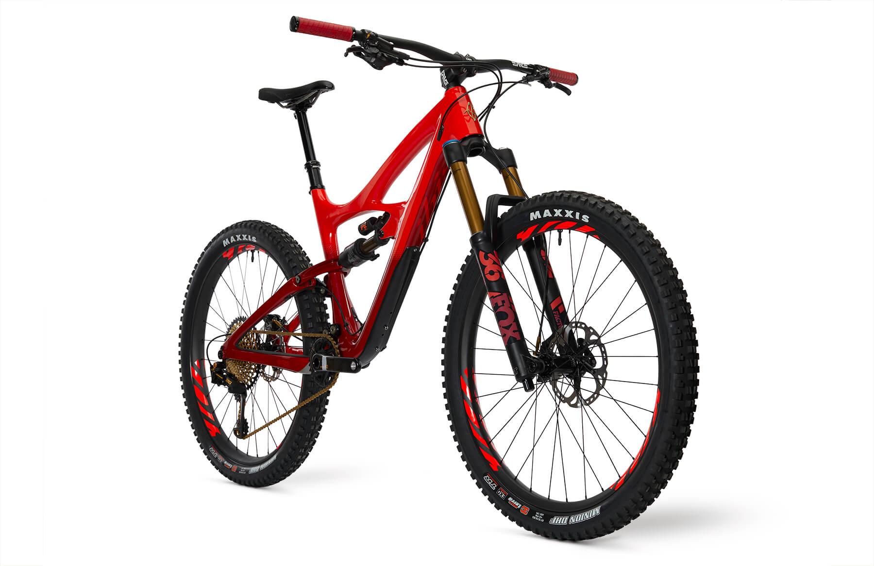 Ibis Mojo HD4: A red mountain bike with a sleek frame and thick tires, featuring black and gold components. The bike is positioned at an angle, showcasing its suspension system and disc brakes. The handlebars have red grips, and the tires are branded with "Maxxis." The image has a clean, white background, emphasizing the bike's design and details.