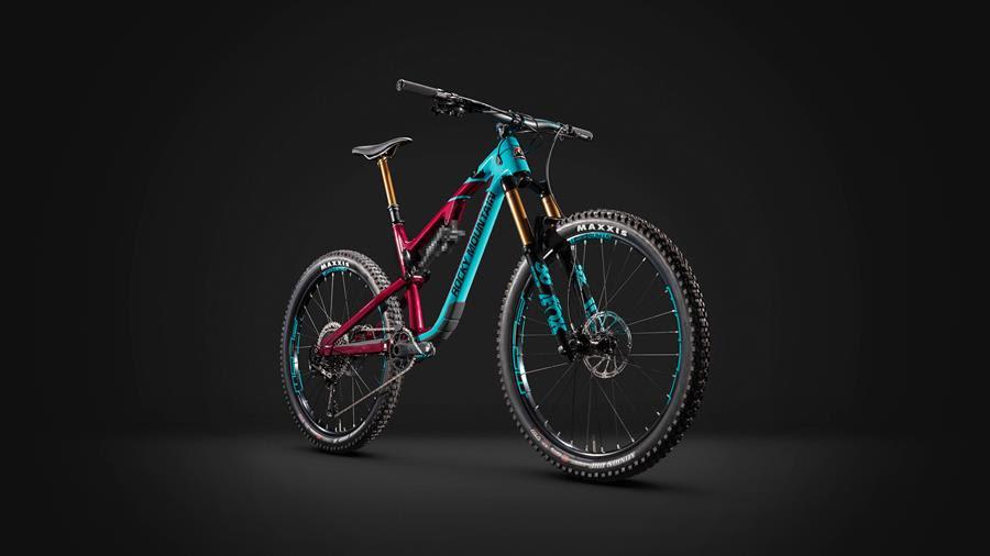 Rocky Mountain Altitude: A vibrant mountain bike with a striking color combination of teal and magenta against a black background. The bike features thick tires, a sturdy frame, and front suspension forks, highlighting its suitability for off-road cycling. The overall design showcases a modern and dynamic aesthetic.