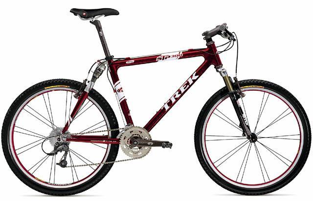 Trek STP 300: A red and white Trek mountain bike showcasing a sleek design with dual suspension and chunky tires, positioned against a plain background. The bike features a lightweight frame, gear shifters on the handlebars, and a comfortable saddle, ideal for off-road riding.