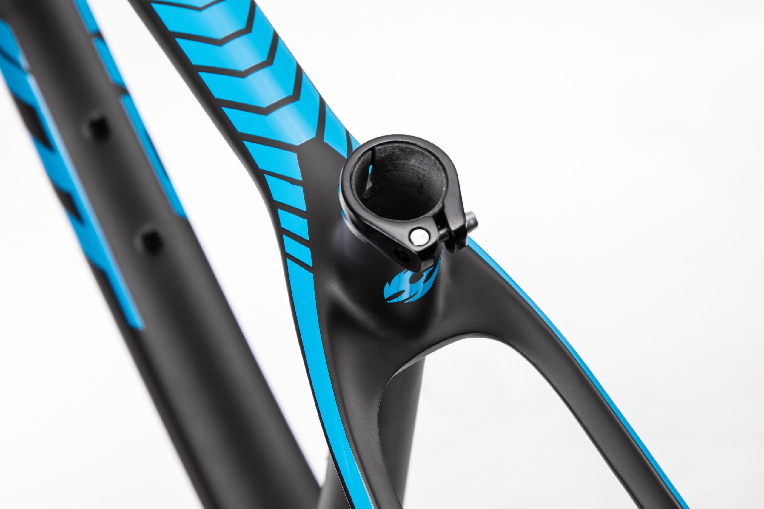 Pivot LES 27.5: Close-up view of a bicycle frame featuring a sleek black design with vibrant blue accents. The image highlights the top tube and collar, showcasing the frame's modern aesthetic and attention to detail. The background is neutral to enhance focus on the frame's design elements.