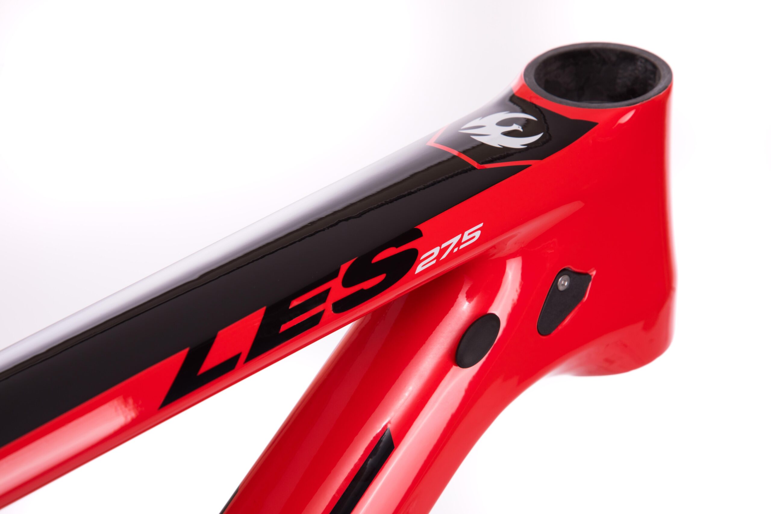 Pivot LES 27.5: Close-up view of a vibrant red bicycle frame with black accents, featuring the text "LES 27.5" prominently displayed on the top tube, showcasing smooth lines and modern design elements.