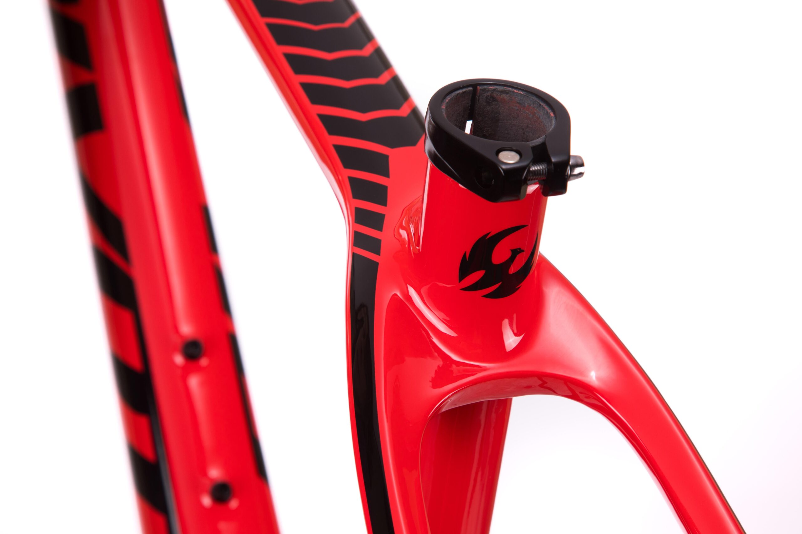 Pivot LES 27.5: Close-up of a vibrant red bicycle frame featuring black accents, with a sleek design that highlights the fork and seat post area. The frame has a glossy finish and decorative elements, including a stylized logo. The background is plain white, emphasizing the bike's striking colors and shapes.