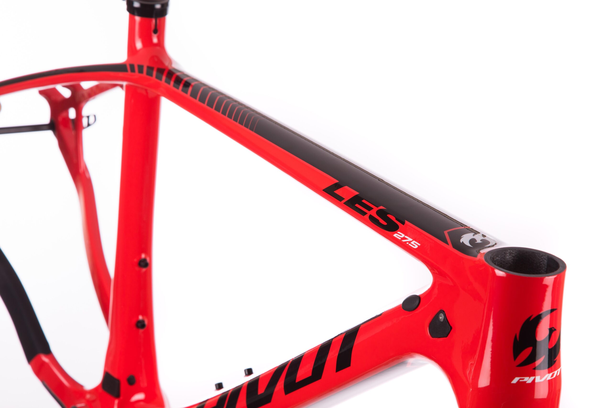 Pivot LES 27.5: Image of a bright red bicycle frame with black accents, featuring the model name "LES 27.5" prominently displayed. The frame showcases a sleek design, highlighting the tubing and connection points. The background is white, emphasizing the bike frame's vivid colors and details.