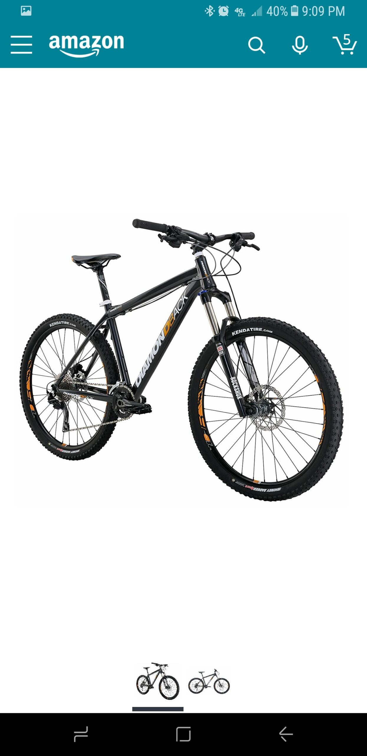 Diamondback Overdrive Comp: Alt text: "A black mountain bike with the brand name 'Diamondback' prominently displayed on the frame, featuring thick tires, front suspension, and disc brakes, set against a plain white background."