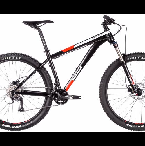 Vitus Nucleus 275 VR: A black and orange mountain bike with thick tires, front suspension, and a sleek frame. The bike features various gears and components designed for off-road cycling, set against a plain white background.