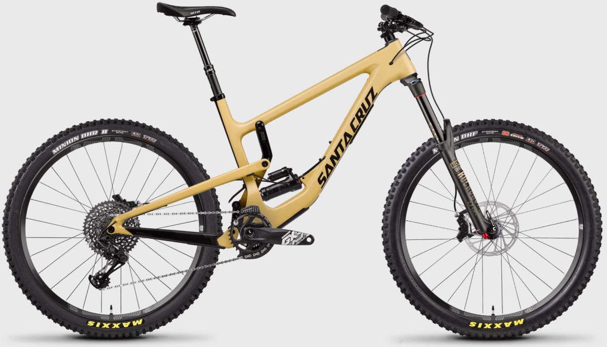 Santa Cruz Nomad: Mountain bike with a lightweight beige frame, featuring thick tires and a modern design. The bike includes front and rear suspension components and a sleek drivetrain. The branding "Santa Cruz" is prominently displayed on the frame.