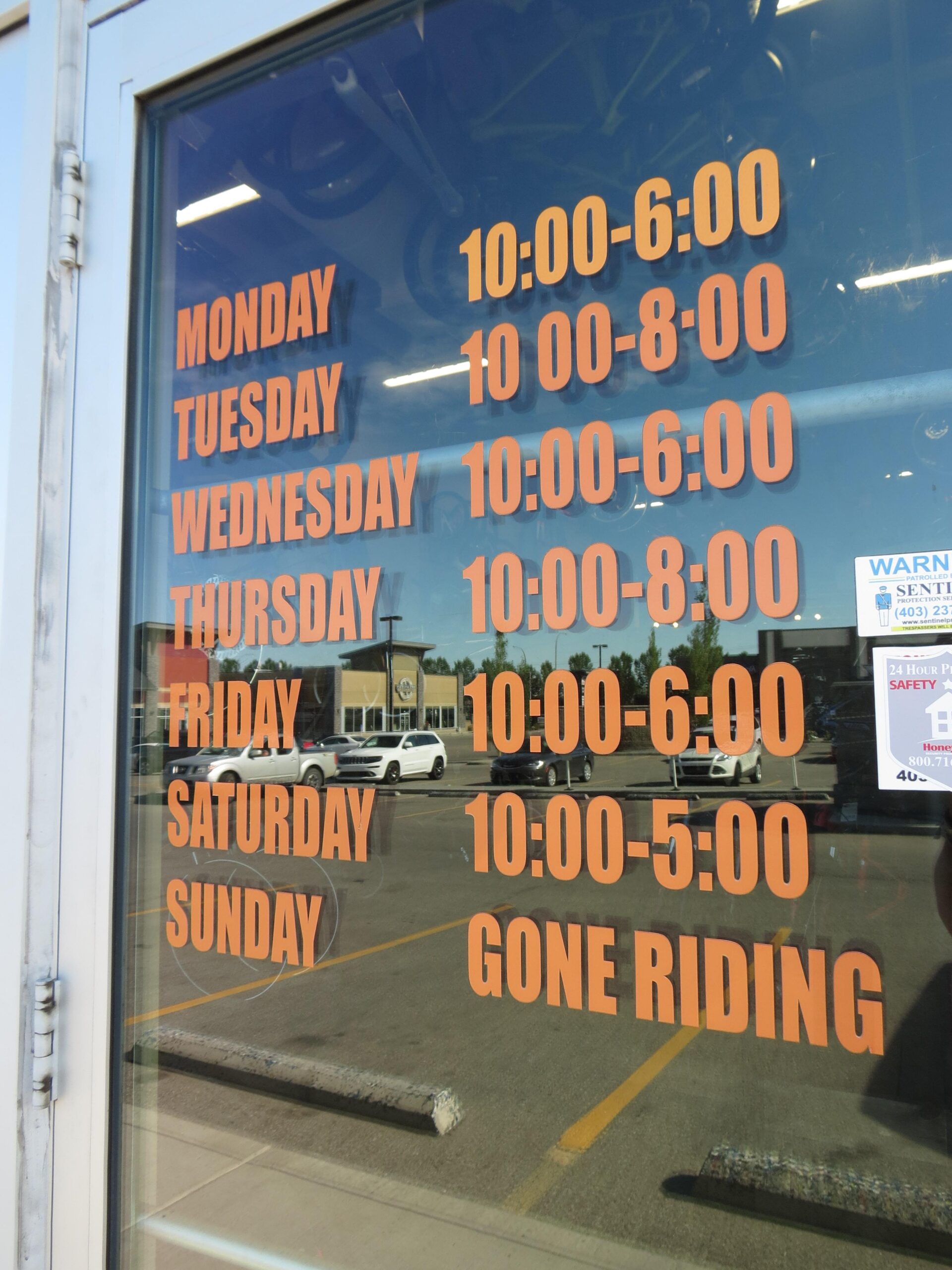 Store hours displayed on a glass window include: 

- Monday: 10:00 AM - 6:00 PM
- Tuesday: 10:00 AM - 8:00 PM
- Wednesday: 10:00 AM - 6:00 PM
- Thursday: 10:00 AM - 8:00 PM
- Friday: 10:00 AM - 6:00 PM
- Saturday: 10:00 AM - 5:00 PM
- Sunday: Gone Riding