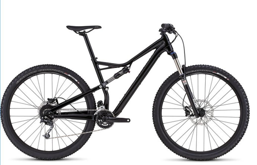 Specialized Camber 29: A sleek black mountain bike with a sturdy frame, wide tires, and a front suspension fork, positioned against a white background. The bike features a modern design, characterized by its disc brakes and multiple gears, making it ideal for off-road trails and rugged terrains.