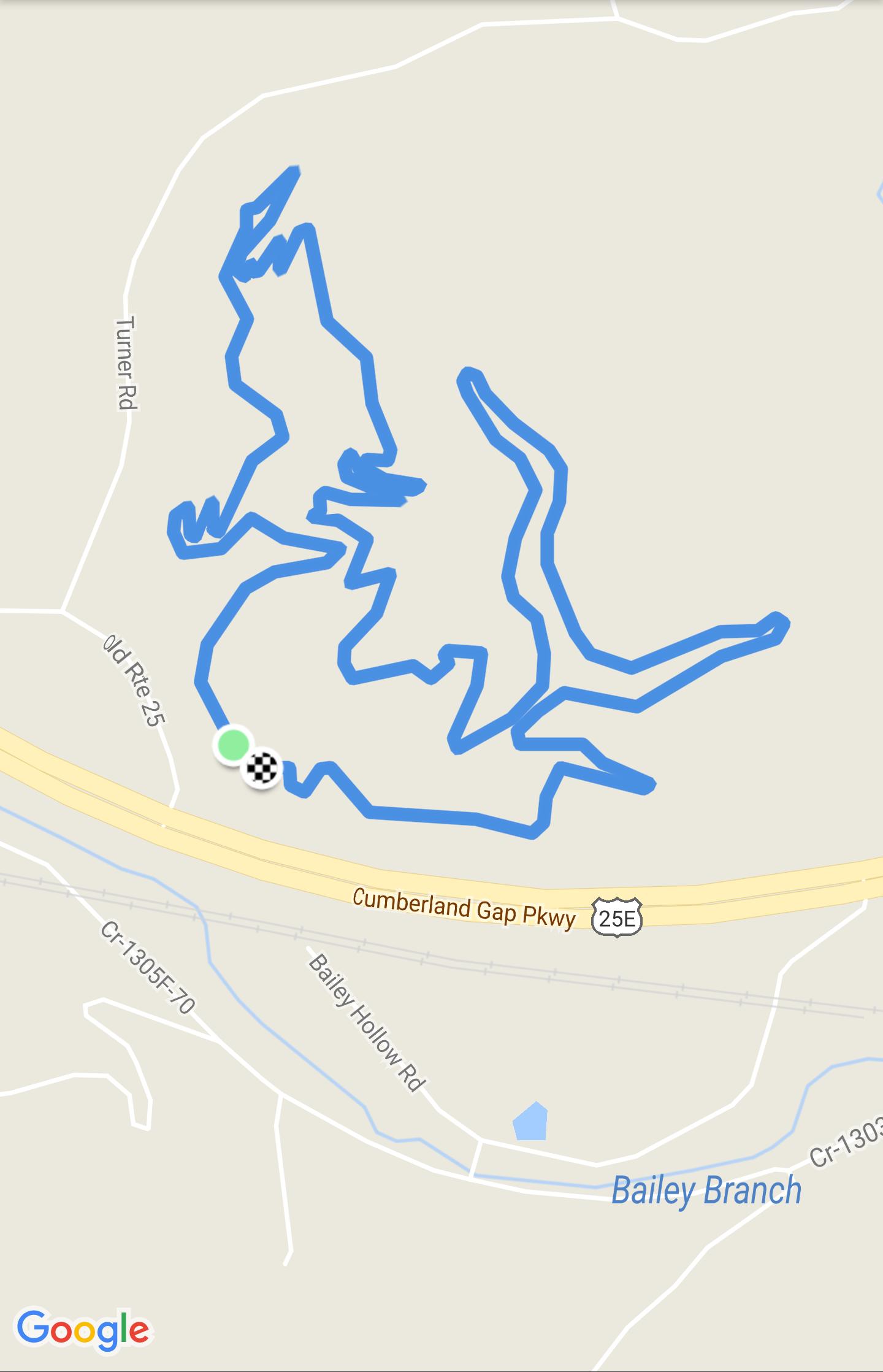 Map showing a winding, blue route through an area near Cumberland Gap Parkway, with nearby roads and landmarks labeled. The route includes sharp turns and curves, indicating a complex path, with a checkered flag and colored markers denoting key points. Turner Outdoor Center mountain bike trail.