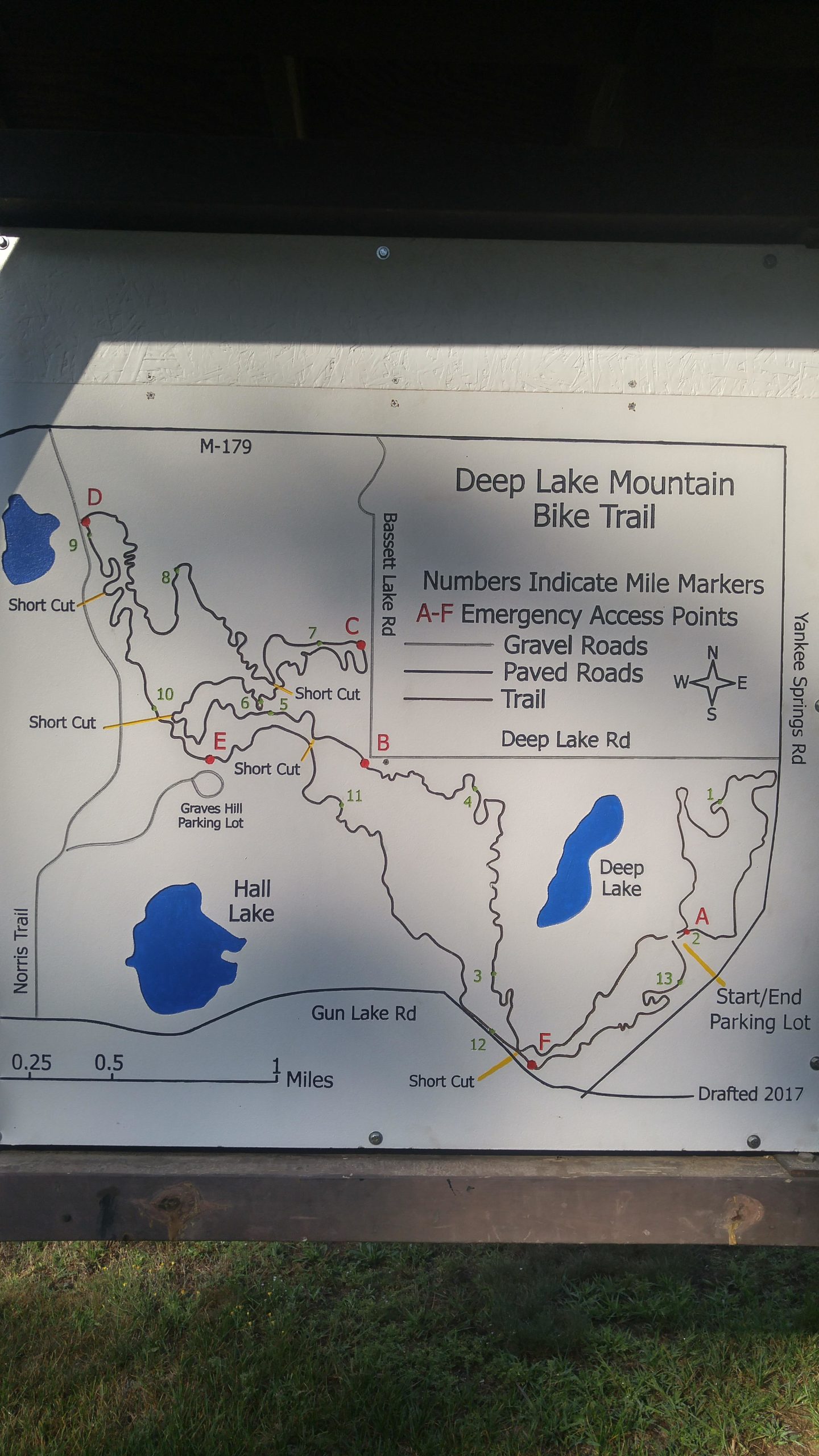 Map of the Deep Lake Mountain Bike Trail, showing routes, mile markers, and emergency access points. Key features include gravel and paved roads, trails, and lakes. Drafted in 2017. Yankee Springs mountain bike trail.