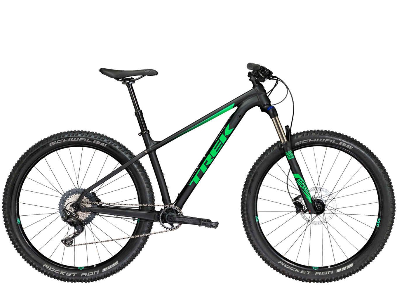 A sleek black mountain bike with green accents, featuring a lightweight frame, wide tires labeled Schwalbe Rocket Ron, and a modern design suitable for off-road cycling.