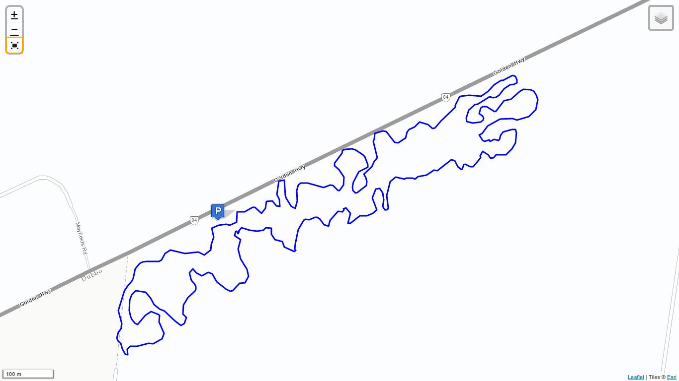 A map showing a section of the Golden Highway, with a blue route marked that features numerous twists and turns. A parking icon is visible along the route, indicating a designated parking area nearby. The background is mostly blank to emphasize the route and the highway. Mugga Hill mountain bike trail.