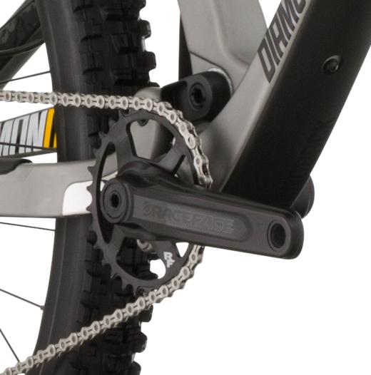 Diamondback Release Carbon: Close-up of a bicycle's crankset, showing the chainring, pedals, and chain. The frame is primarily grey with black components, and the logo "Race Face" is visible on the crank arm.