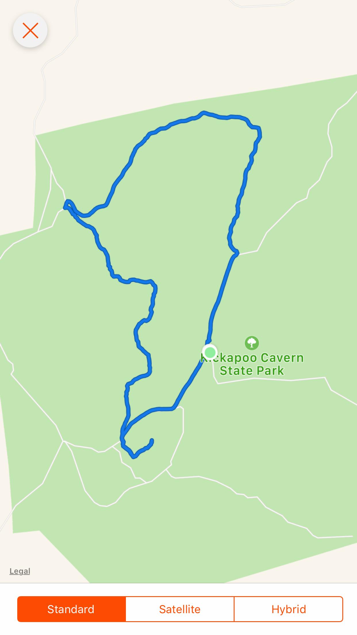 Map showing a blue trail route within the boundaries of Kickapoo Cavern State Park, illustrated with a green background and labeled park name. Kickapoo Cavern State Park mountain bike trail.
