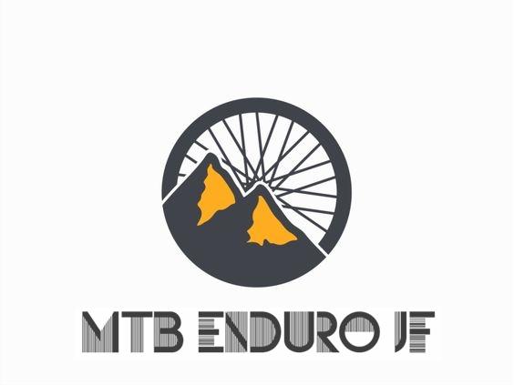 Logo design for "MTB Enduro JF," featuring a circular graphic with a stylized mountain landscape and a bicycle wheel in the background. The mountains are depicted in dark gray with yellow highlights, and the text "MTB ENDURU JF" is displayed in bold, modern typography at the bottom.