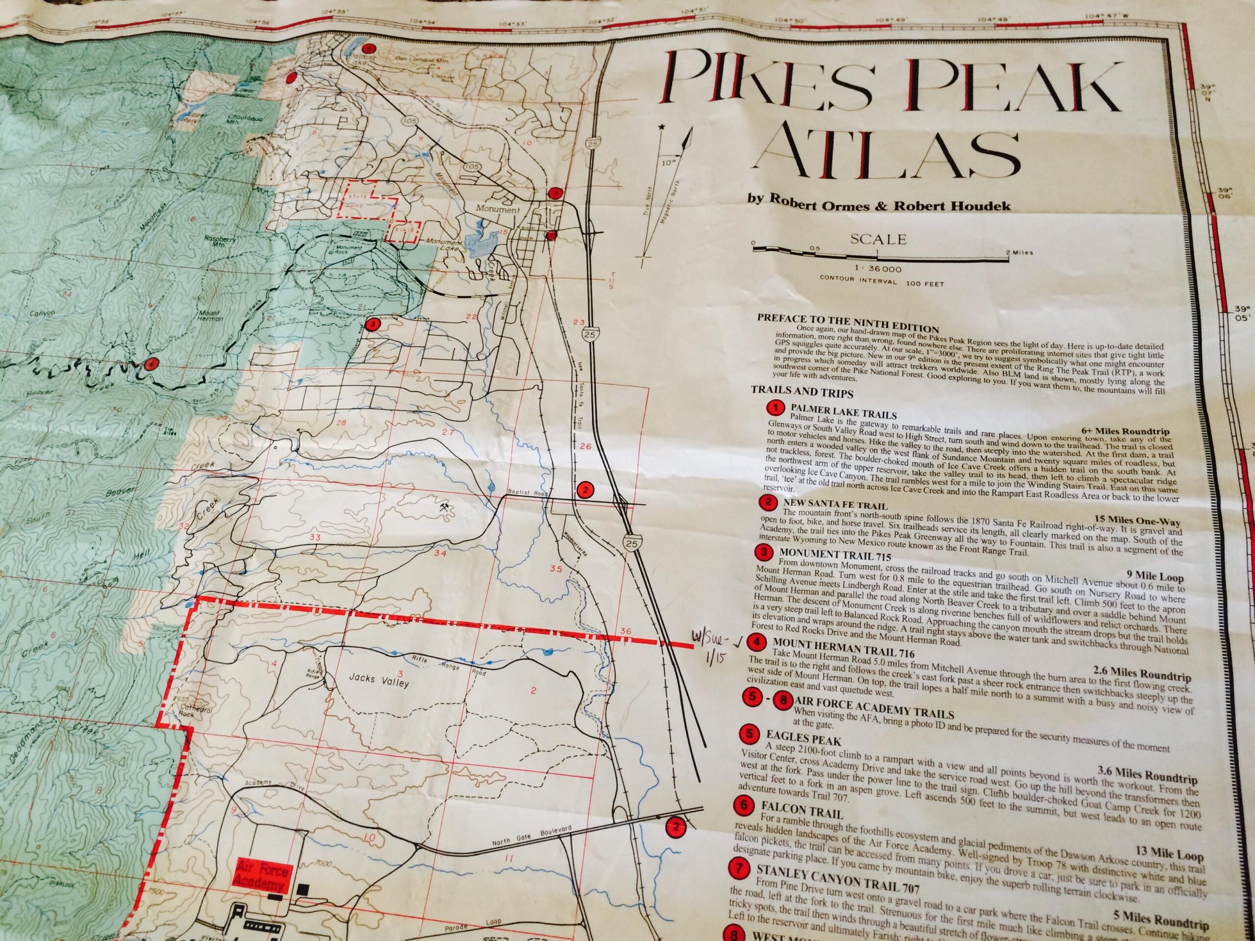 * Pikes Peak Atlas: Alt text: A detailed topographic map titled "Pikes Peak Atlas" by Robert Ormes and Robert Houdek, displaying various trails and trips around the Pikes Peak region. The map includes contour lines, marked trails, and locations such as Palmer Lake, the New Santa Fe Trail, and Falcon Trail, with a scale indicating a distance of 1 mile.