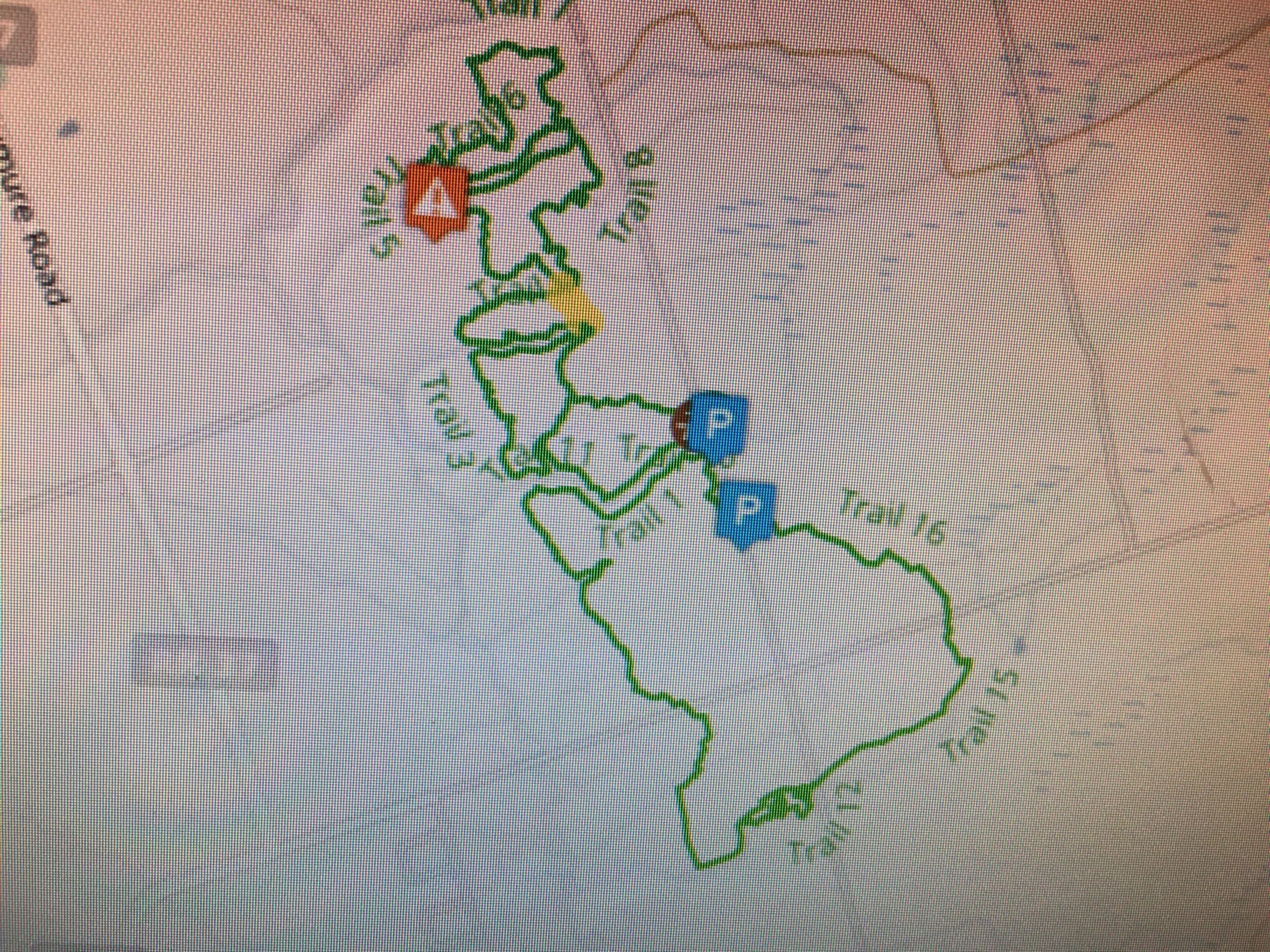 Map showing a network of trails, marked in green, with specific trails labeled as "Trail 1," "Trail 2," "Trail 3," and so on, including parking areas indicated by blue symbols. The map also features a highlighted area marked with an orange number "4." Larose Forest mountain bike trail.