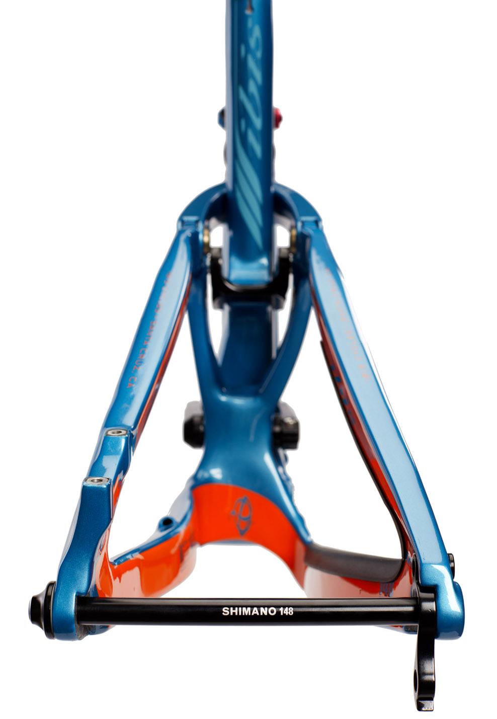 Ibis RipMo: Alt text: Close-up view of a blue and orange bicycle frame featuring a Shimano 148 rear axle. The image shows the bike's suspension linkage and lower section in detail, emphasizing the design and color contrast.