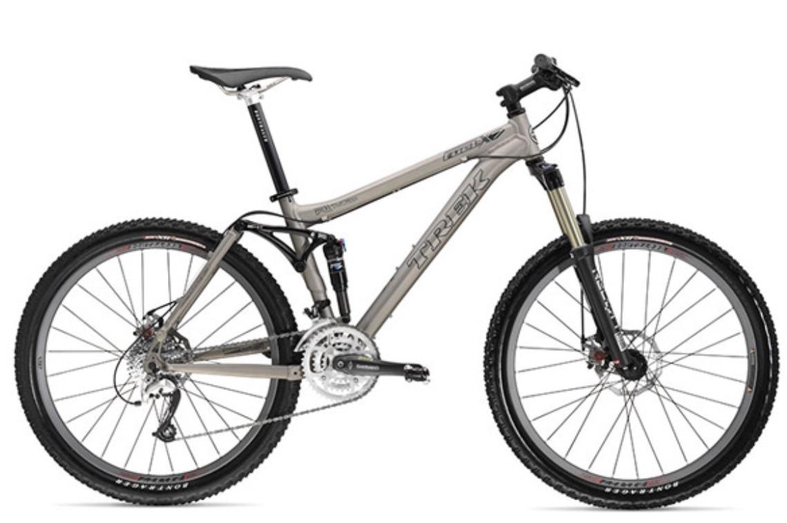 Trek Fuel EX 7: A mountain bike with a gray and black frame, featuring front suspension, disc brakes, and rugged tires designed for off-road riding. The bike has a comfortable saddle and a gear system for varied terrain.