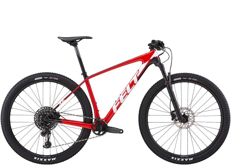 Felt Doctrine 3: A red mountain bike with a lightweight frame and sleek design, featuring wide tires, a front suspension fork, and modern gearing components. The bike is positioned against a neutral background, showcasing its racing aesthetics and performance features.