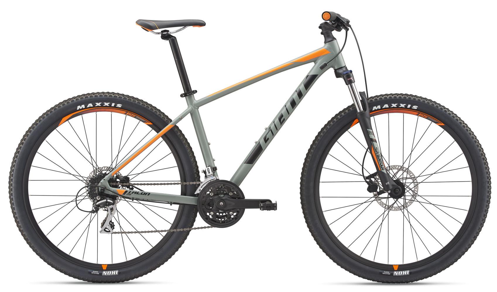 2017 Giant Talon 3: A rugged mountain bike with a gray frame featuring orange accents, equipped with thick tires and a front suspension fork, positioned against a plain white background.