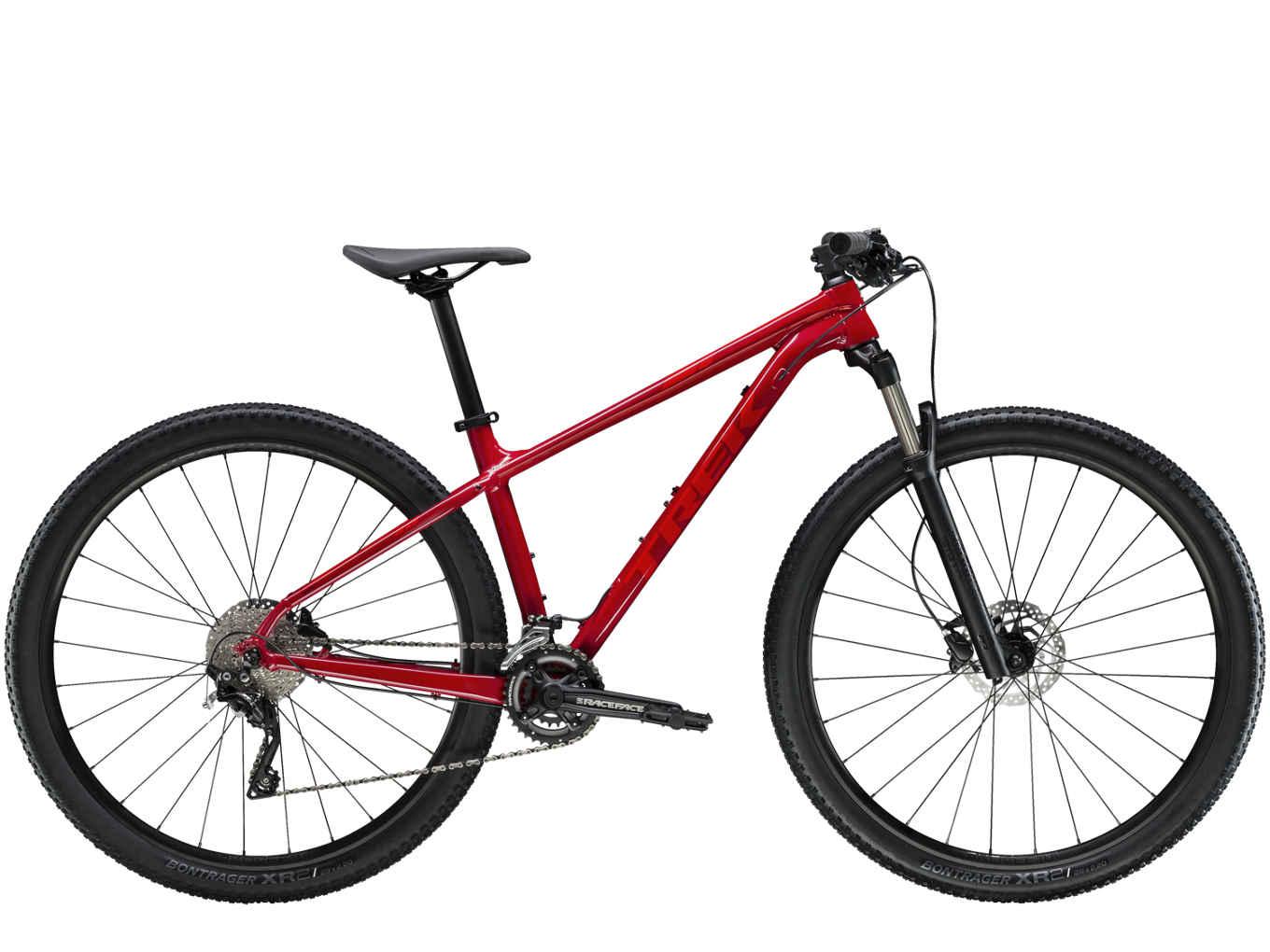 Trek X-Caliber 8: A modern mountain bike with a sleek red frame, featuring front suspension, wide tires, and a gear system. The bike is positioned on a white background.