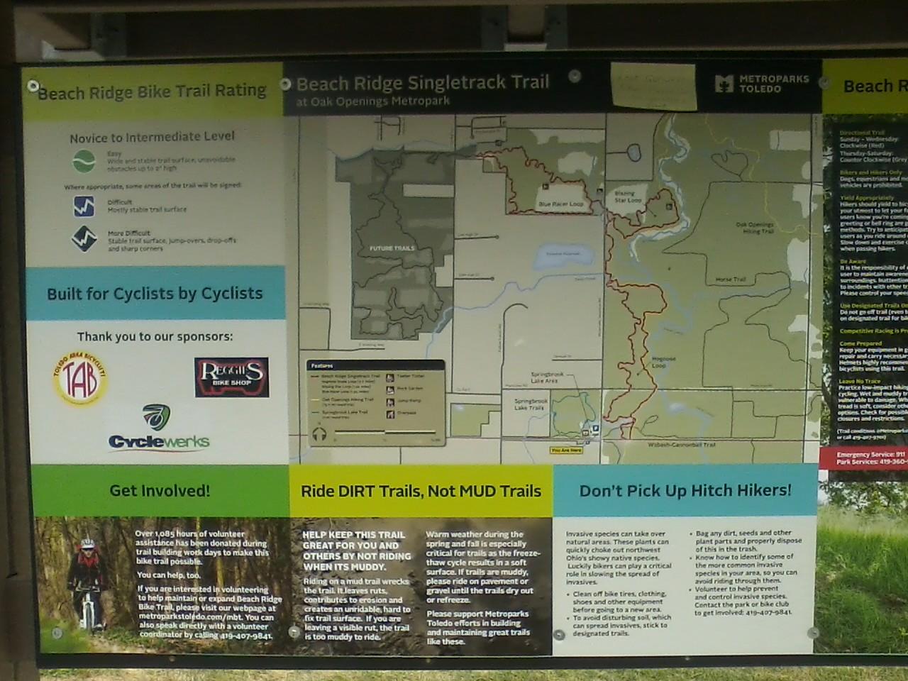 Image alt tag: informational sign for Beach Ridge Bike Trail at Oak Openings Metropark, featuring trail ratings, a map of the area, and guidelines for cyclists, along with sponsor logos and volunteer information. Oak Openings -- Beach Ridge Singletrack Trail mountain bike trail.