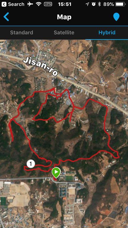 A hybrid map showing a marked hiking route in the Jisan-ro area. The path is outlined in red and includes various twists and turns through a mostly wooded terrain, with surrounding areas of farmland and urban development. A green marker indicates the starting point of the route. Buraksan mountain bike trail.
