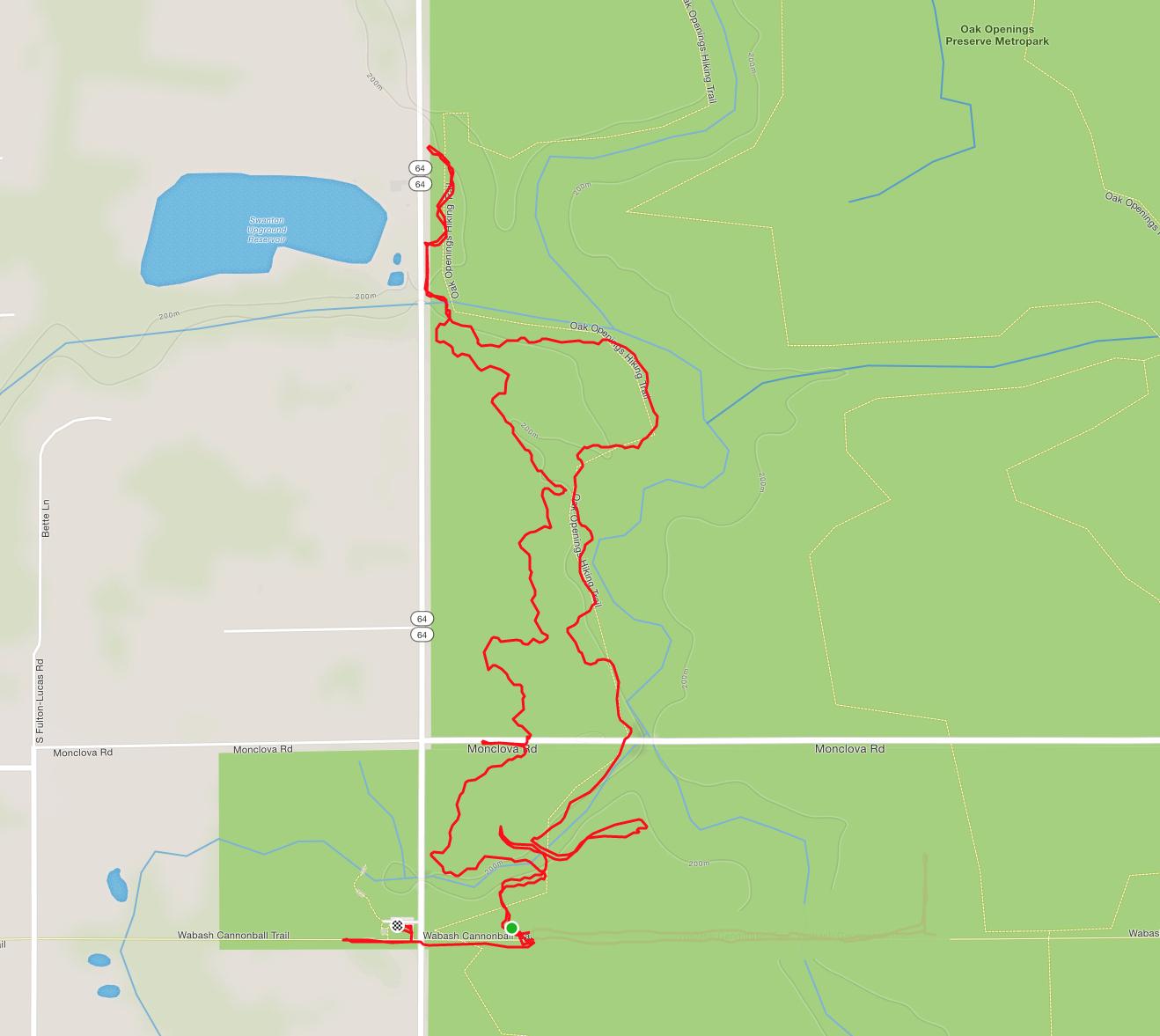 Map showing a marked trail in a natural area, including the Wabash Cannonball Trail and surrounding green spaces. The red path indicates the route taken, with nearby roads and a blue lake represented. Oak Openings -- Beach Ridge Singletrack Trail mountain bike trail.