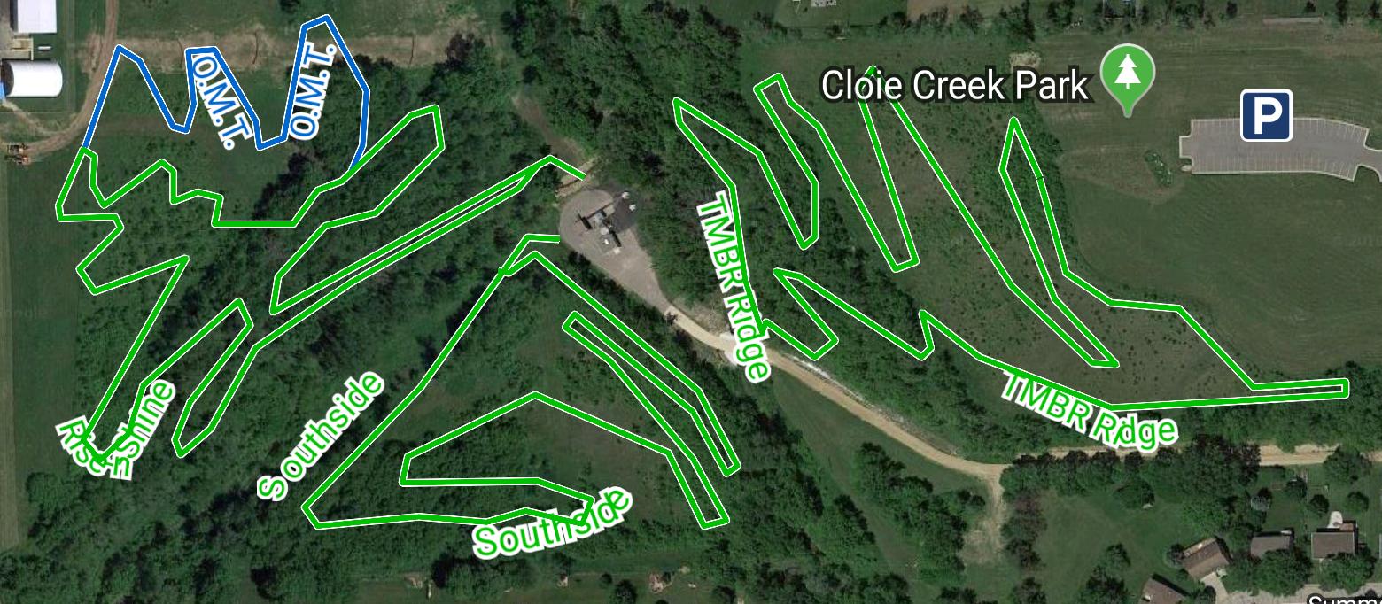 Map of Cloie Creek Park showing various trails outlined in green, with marked trails like "TMBR Ridge" and "Rice Shrine." A parking area is located at the top right, alongside wooded areas and paths through the park. Cloie Creek Park mountain bike trail.