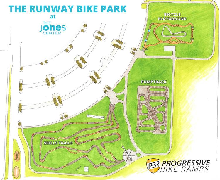 A detailed map of The Runway Bike Park at The Jones Center, featuring designated areas such as skills trails, a pumptrack, and a bicycle playground, with paths and layout indicated. The design includes green spaces and adjacent parking areas, along with the Progressive Bike Ramps logo. Runway Bike Park @ The Jones Center mountain bike trail.