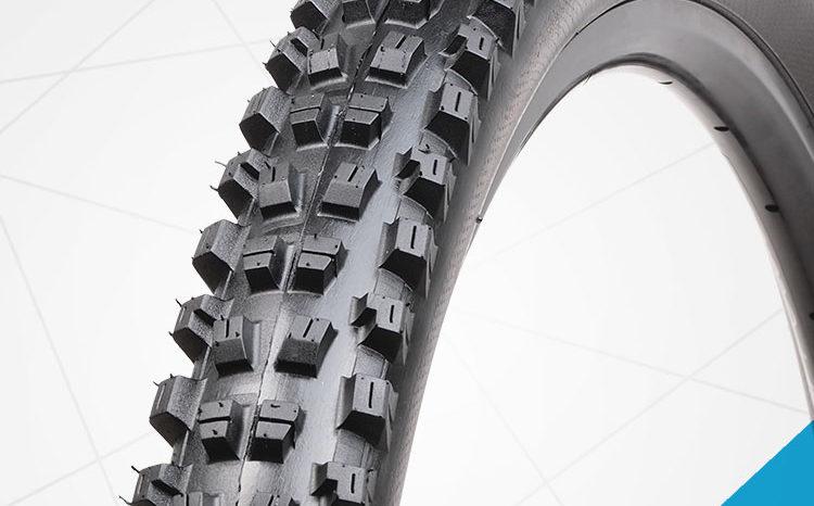 Vee Snap WCE: Close-up of a rugged mountain bike tire showcasing its aggressive tread pattern designed for improved traction on off-road surfaces. The tire features prominent, angular knobs that enhance grip and stability.