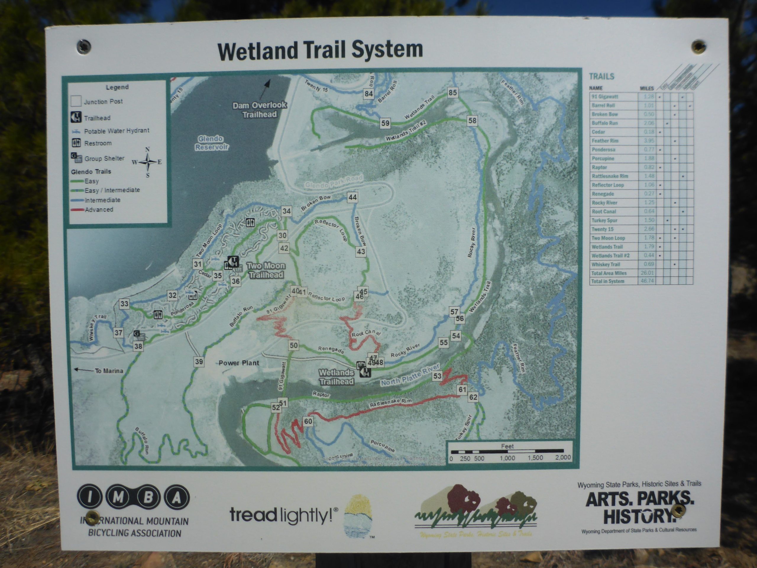 Map of the Wetland Trail System, outlining various trails for hiking and biking. Includes a legend with symbols for trailheads, restrooms, and water hydrants, as well as a list of trails with their lengths and difficulty levels. The map displays features such as Glendo Reservoir and connecting trails like the Two Moon Trailhead and Wetlands Trailhead. Glendo State Park mountain bike trail.