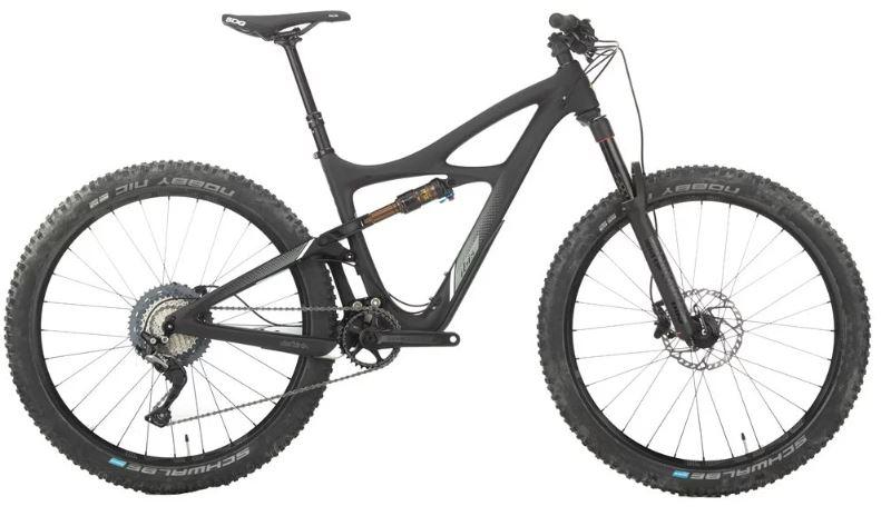 Ibis Mojo 3: A side view of a modern mountain bike featuring a sleek black frame, wide tires, and a multi-gear drivetrain. The bike has a suspension system with a visible shock, designed for off-road performance. The tires have a rugged tread pattern, suitable for various terrains.