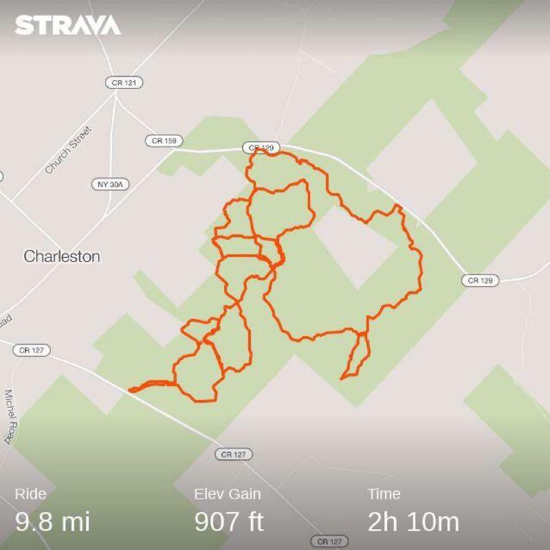 A map showing a cycling route in Charleston, featuring an orange line that traces the path taken. Key data includes a total distance of 9.8 miles, an elevation gain of 907 feet, and a total ride time of 2 hours and 10 minutes. Charleston ski trails mountain bike trail.