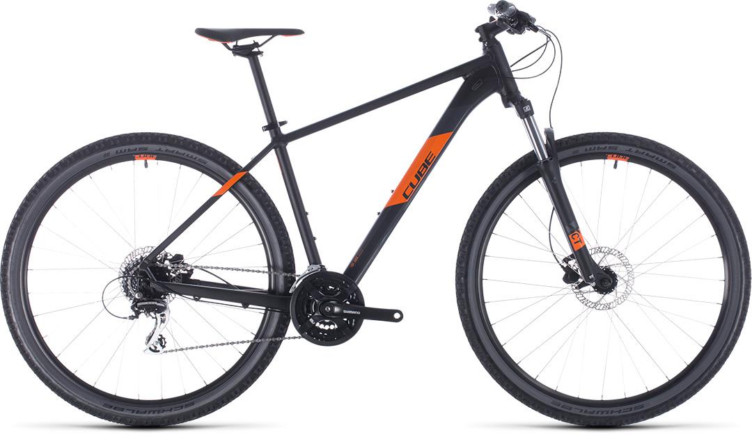 Cube Aim Pro 2020: Alt text: A black and orange Cube mountain bike with thin tires and a sleek design, featuring a lightweight frame, disc brakes, and Shimano components, positioned side on against a white background.