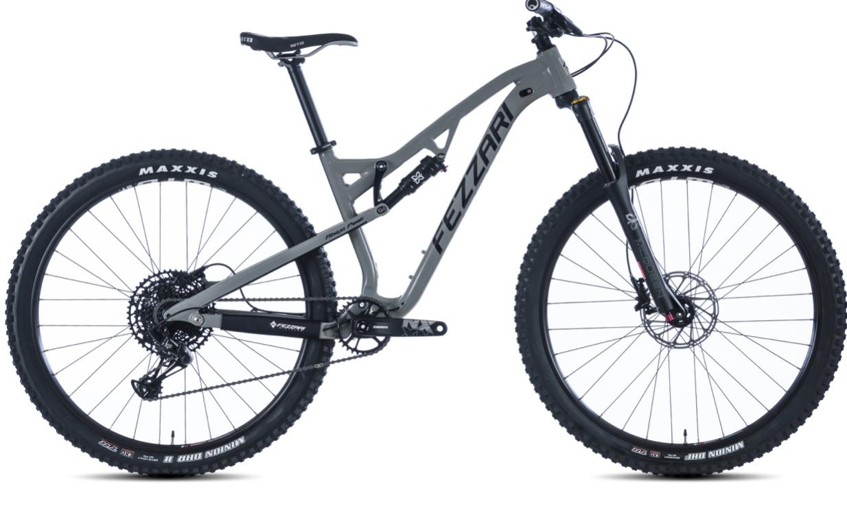 Fezzari Abajo Peak: Alt text: A side view of a mountain bike featuring a sturdy gray frame, wide tires, and suspension for off-road riding. The bike is equipped with a black drivetrain and branding visible on the frame and tires.