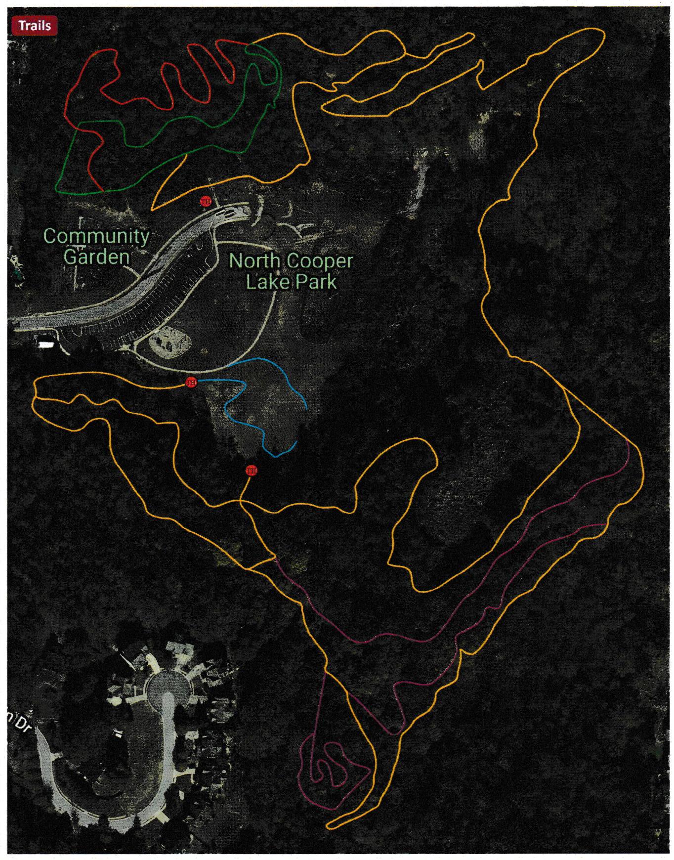 Map showing the trail layout of North Cooper Lake Park, with marked trail routes in various colors including green, red, yellow, blue, and pink. Key features include the Community Garden and pathways connecting different areas of the park. North Cooper Lake Park Trail mountain bike trail.