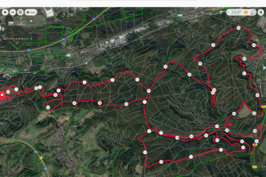 Map displaying a trail route in a forested area near Kindsbach and Bann, featuring a red path along with markers indicating points of interest or checkpoints. Green paths represent additional trails or paths in the surrounding area. The map includes geographical features like roads, towns, and forested landscapes. melkerei 45Km loop mountain bike trail.