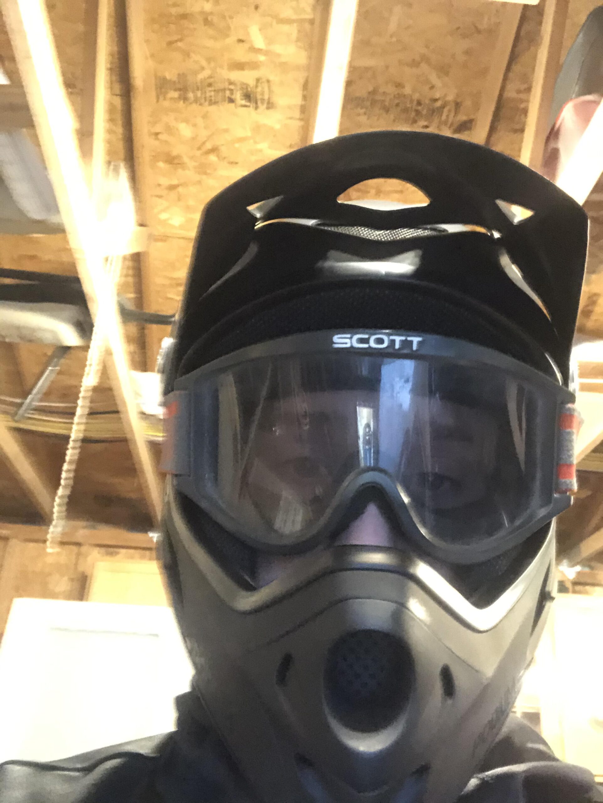 Specialized Hardrock Sport Disc 29er: A person wearing a full-face mask and goggles, with a black helmet, in a well-lit indoor space with wooden beams overhead.